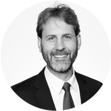 Headshot - David Noon- A black and white photo of a man in a suit and tie taking a company photo