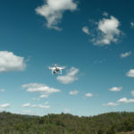 A white GroundProbe drone using BlastVision flying in the sky above a mine site