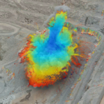 A close-up bird's eye view of a mining site with a GroundProbe BlastVision software heatmap layer on top of the photo to highlight slope instability